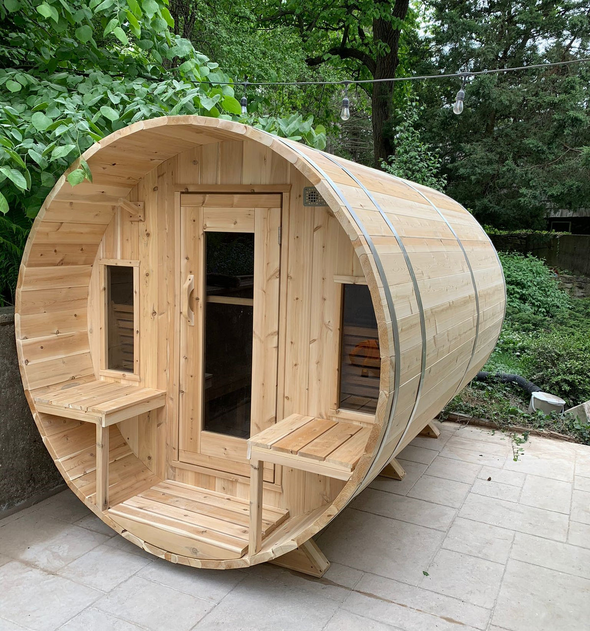 Main view of Leisurecraft Canadian Timber Tranquility Outdoor Barrel Sauna in an outdoor setting with a forest in the background.