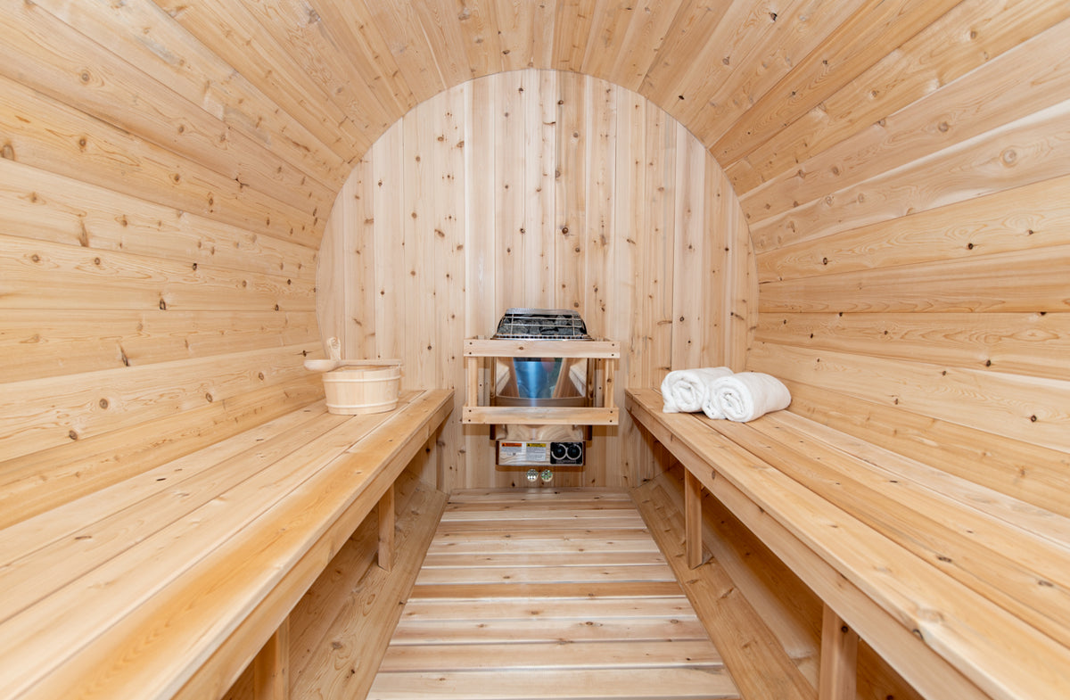 Interior view of the Leisurecraft Canadian Timber Tranquility Outdoor Barrel Sauna, showcasing its large capacity, benches and heater.