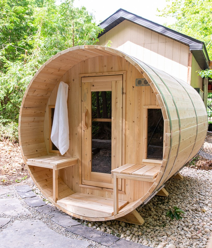 Leisurecraft Canadian Timber Tranquility Outdoor Barrel Sauna installed in the garden of a house.