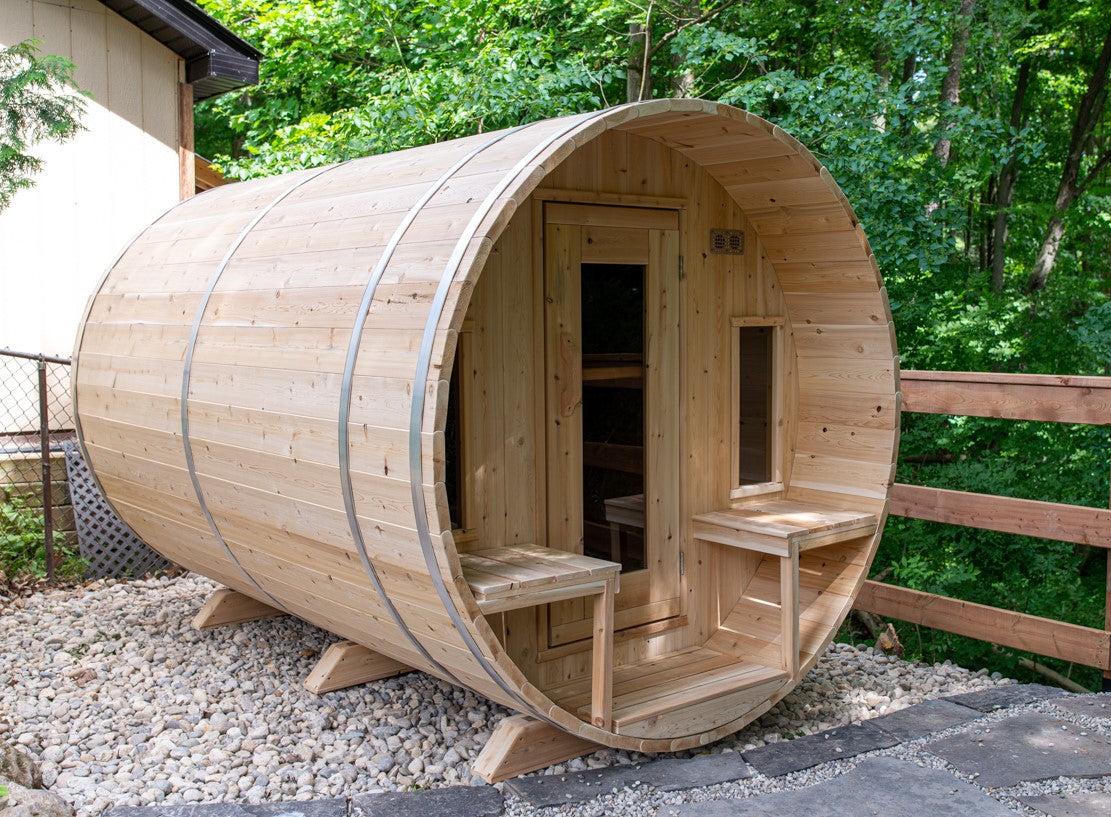 Side view of Leisurecraft Canadian Timber Tranquility Outdoor Barrel Sauna in an outdoor setting surrounded by nature.