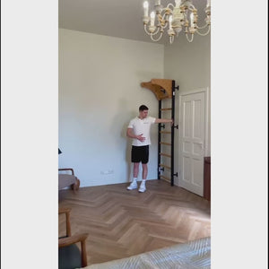 Video of a man exercising with BenchK 711 Wall Bars and Gymnastic Ladders with wooden pull-up bar installed in a living room.