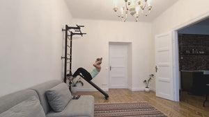 Video of a woman exercising with BenchK 723 Wall Bars and Gymnastic Ladders installed in a living room.