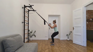 A video of a woman exercising with BenchK 721 Wall Bars and Gymnastic Ladders installed in a living room.